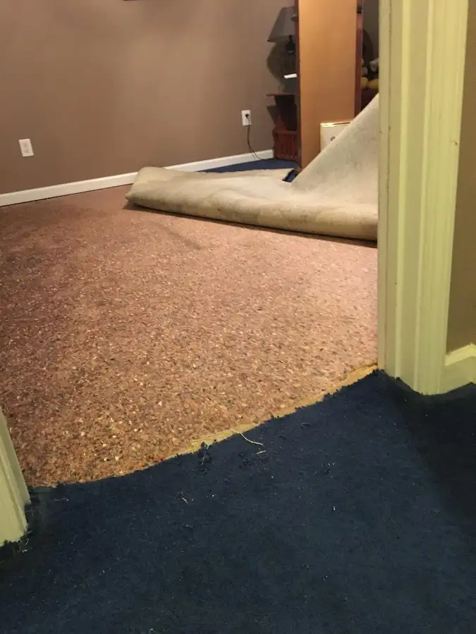 Carpet pad removal revealing water damage during Water Mitigation Services in Kronenwetter